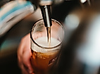 Frisch gezapftes Craft Beer fließt in ein Glas, Nahaufnahme an der Theke im Hamburger Nachtleben