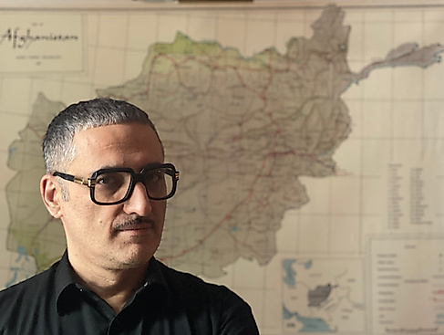 Prof. Dr. Fahim Amir stands in front of a map, looking serious