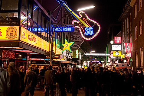 Belebte Große Freiheit bei Nacht mit leuchtenden Clubschildern und Gitarren-Neonreklame