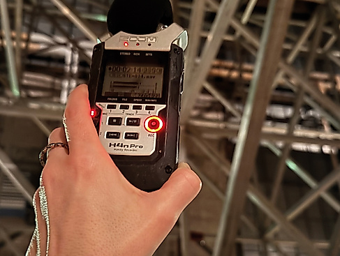 A person is holding a portable audio recorder.