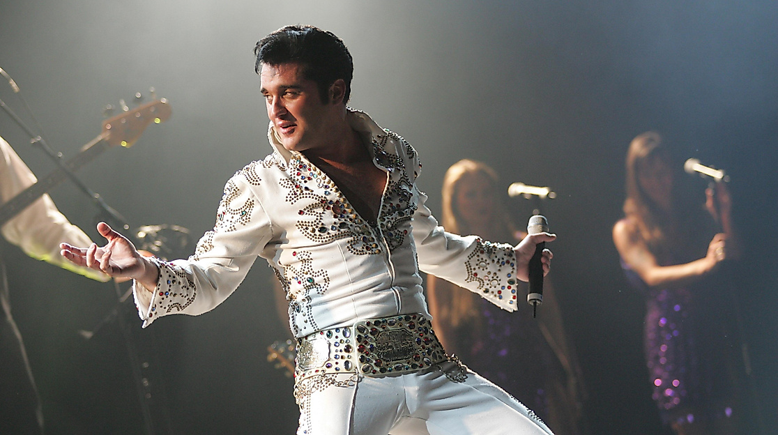 Bühnenbild mit Elvis Presley Darsteller im Vordergrund und Background Band im Hintergrund