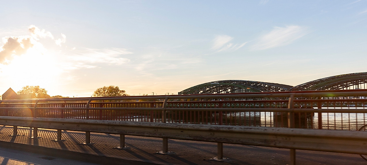 Elbbrücken zwischen Wilhelmsburg und Veddel in Hamburg im Sonnenlicht mit Gleisen und Wasser im Vordergrund