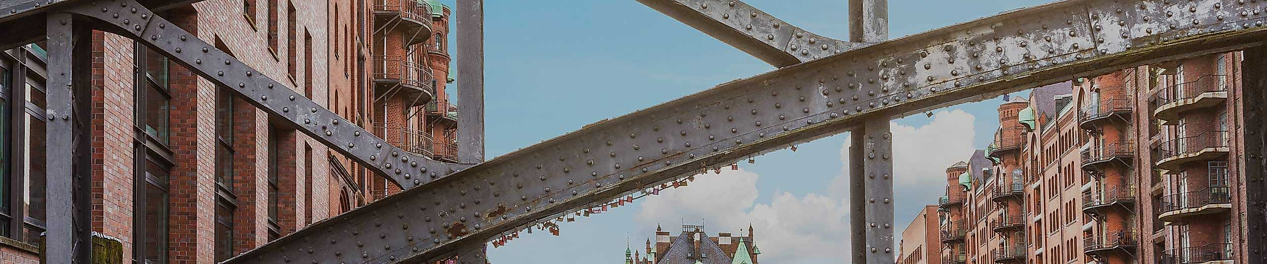 Radfahrer:innen überqueren Brücke zwischen historischen Backsteinbauten in der Hamburger Speicherstadt