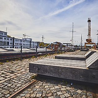 Blick auf den Lotsekai am Harburger Hafenmuseum in Hamburg mit Kaimauer, Kränen und moderner Uferbebauung