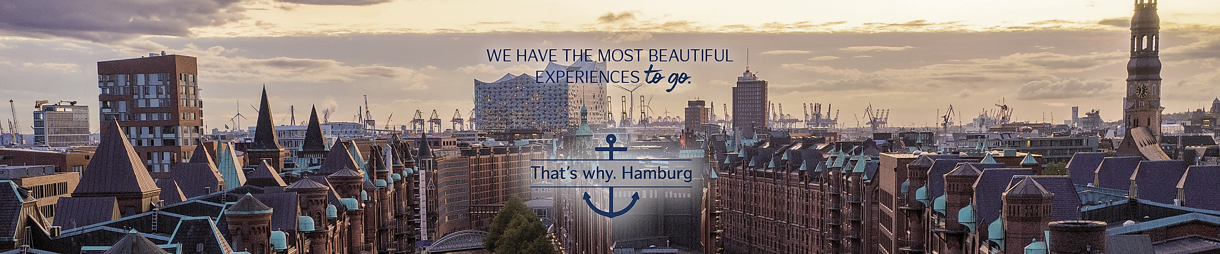 Panoramic view of Hamburg’s port and Speicherstadt at sunset with the Elbphilharmonie in the center with text " WE HAVE THE MOST BEAUTIFUL EXPERIENCES TO GO". THAT´S WHY. HAMBURG