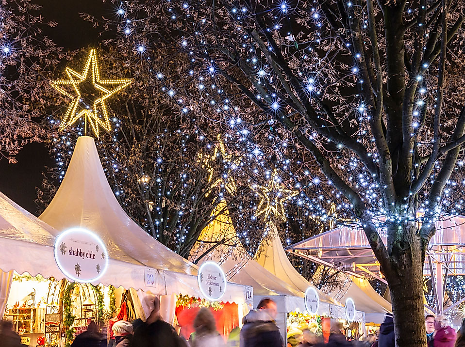 Weihnachtsmarkt in Hamburg mit festlich beleuchteten Zelten und Lichterglanz in den Bäumen bei Nacht