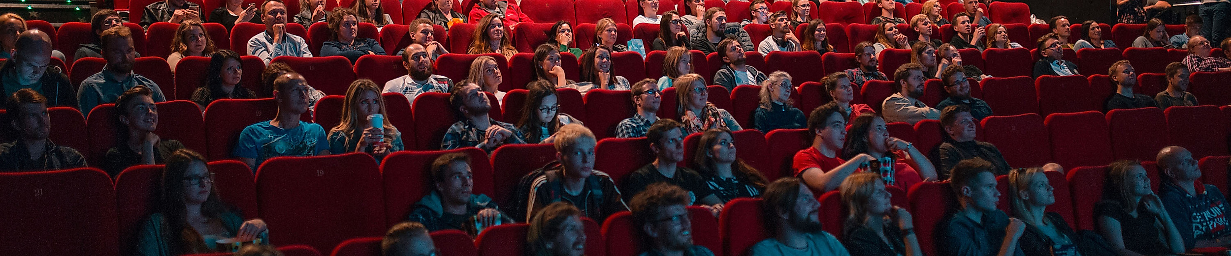Kinosaal mit rotem Gestühl und vielen Zuschauer:innen während einer Filmvorführung in Hamburg