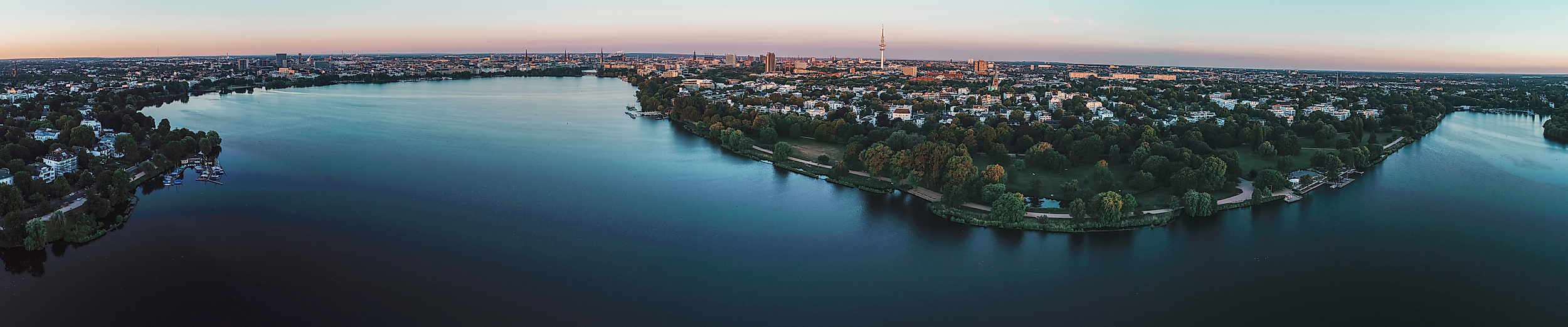Panorama der beleuchteten Außenalster in der Morgendämmerung mit Blick auf das umliegende Stadtgebiet