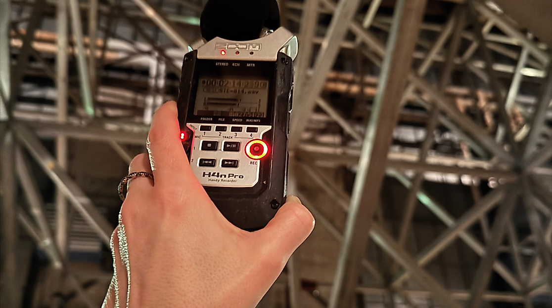 A person is holding a portable audio recorder.