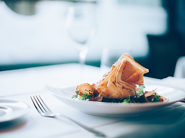 Gedämpfte asiatische Teigtaschen in Bambuskörbchen, serviert mit Dip und Stäbchen auf dunklem Untergrund